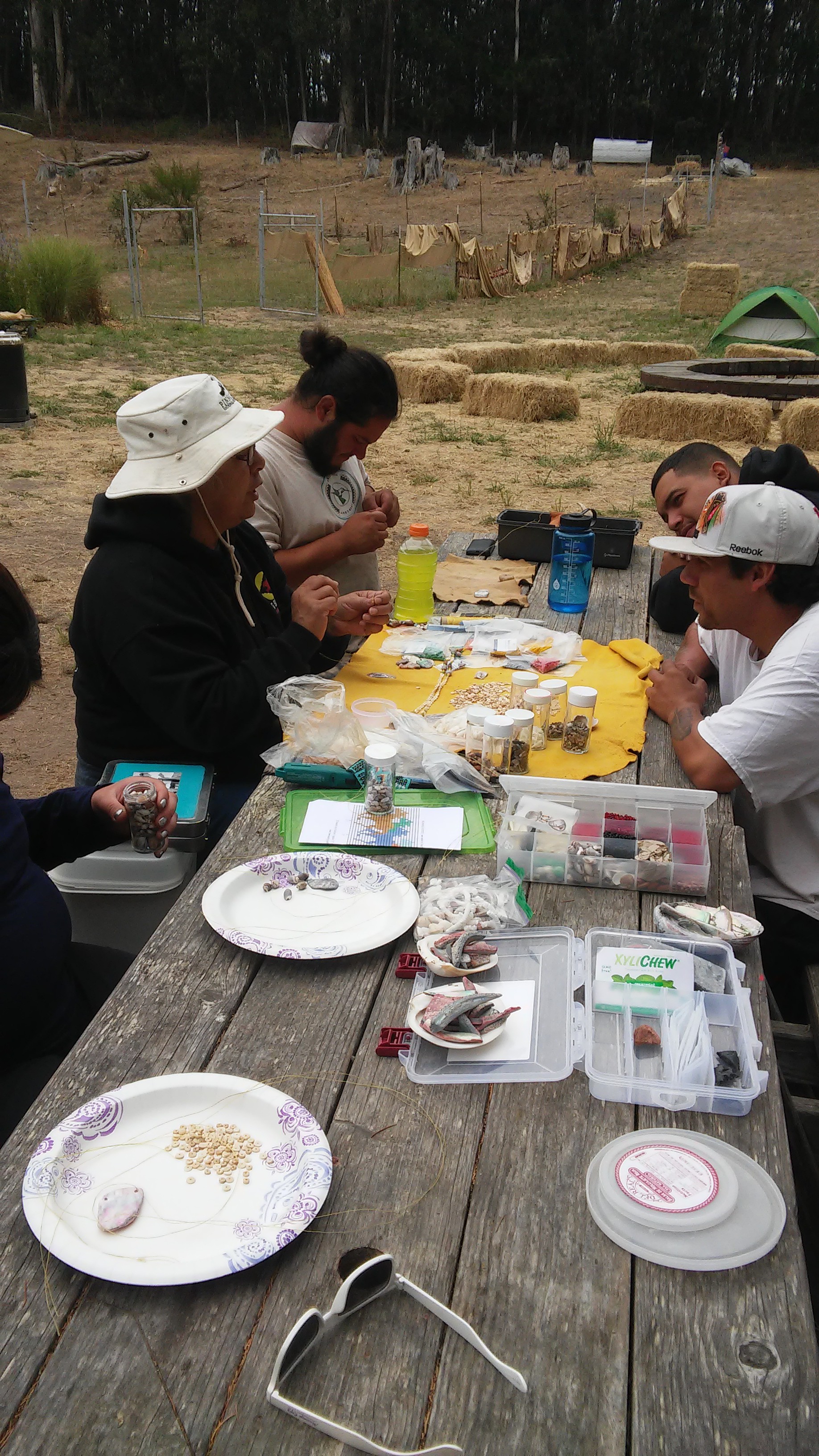 Tribal Elder Eleanor Castro leads a beading workshop with the Native Stewards. During NSC, the stewards participate in daily cultural and educational activities to strengthen a sense of Mutsun identity.
