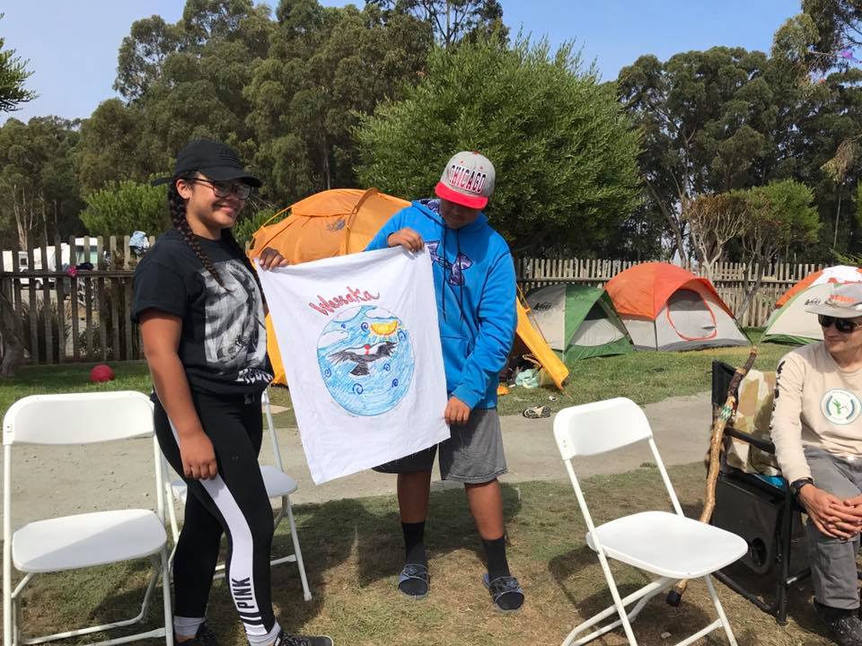 Members of the Wassaka (Condor) group share their team flag. Photo courtesy Abran Lopez.