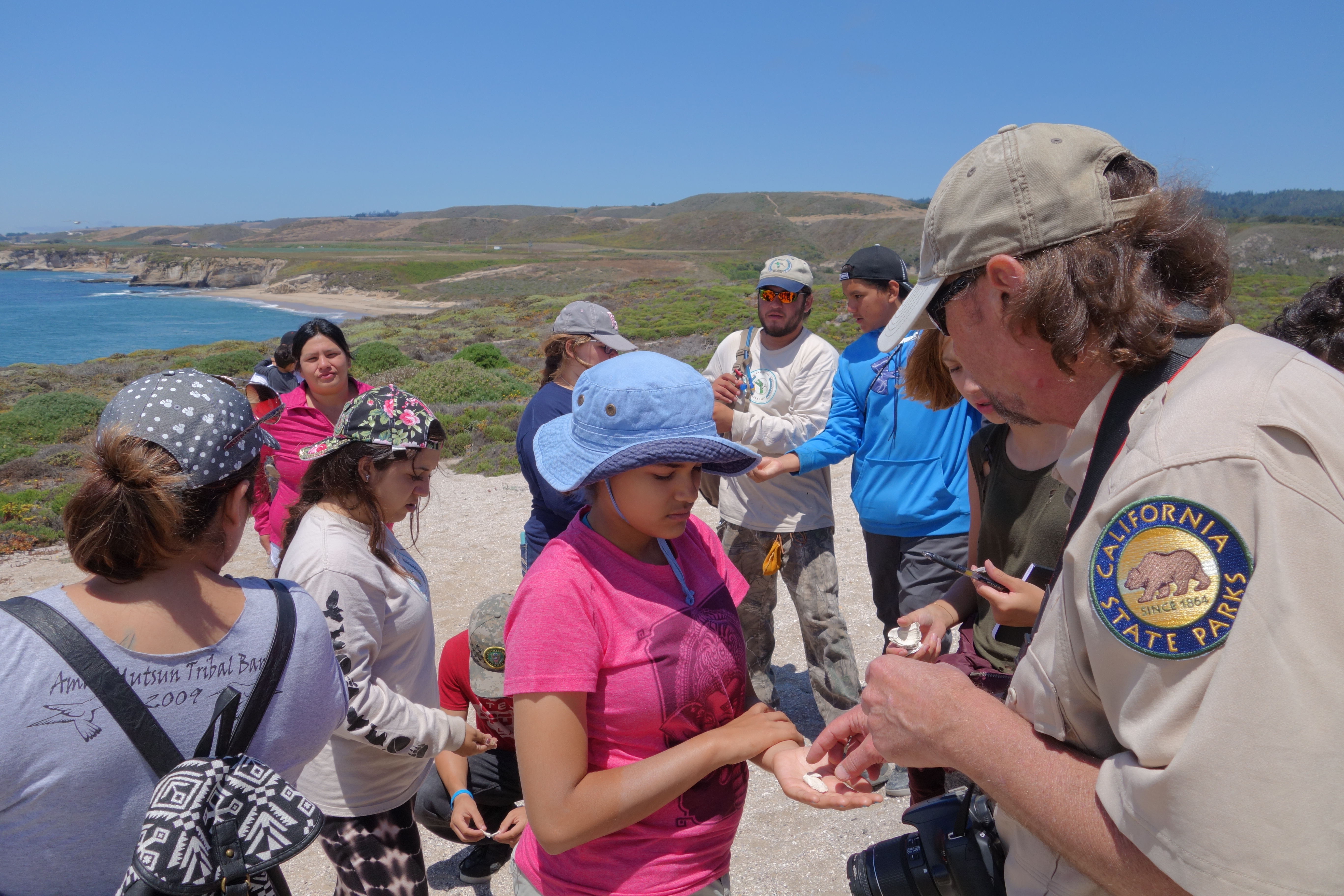 Campers visited and worked to protect Amah Mutsun archaeological sites. Here Mark Hylkema, State Parks archaeologist, describes an artifact. Photo courtesy Cat Wilder.